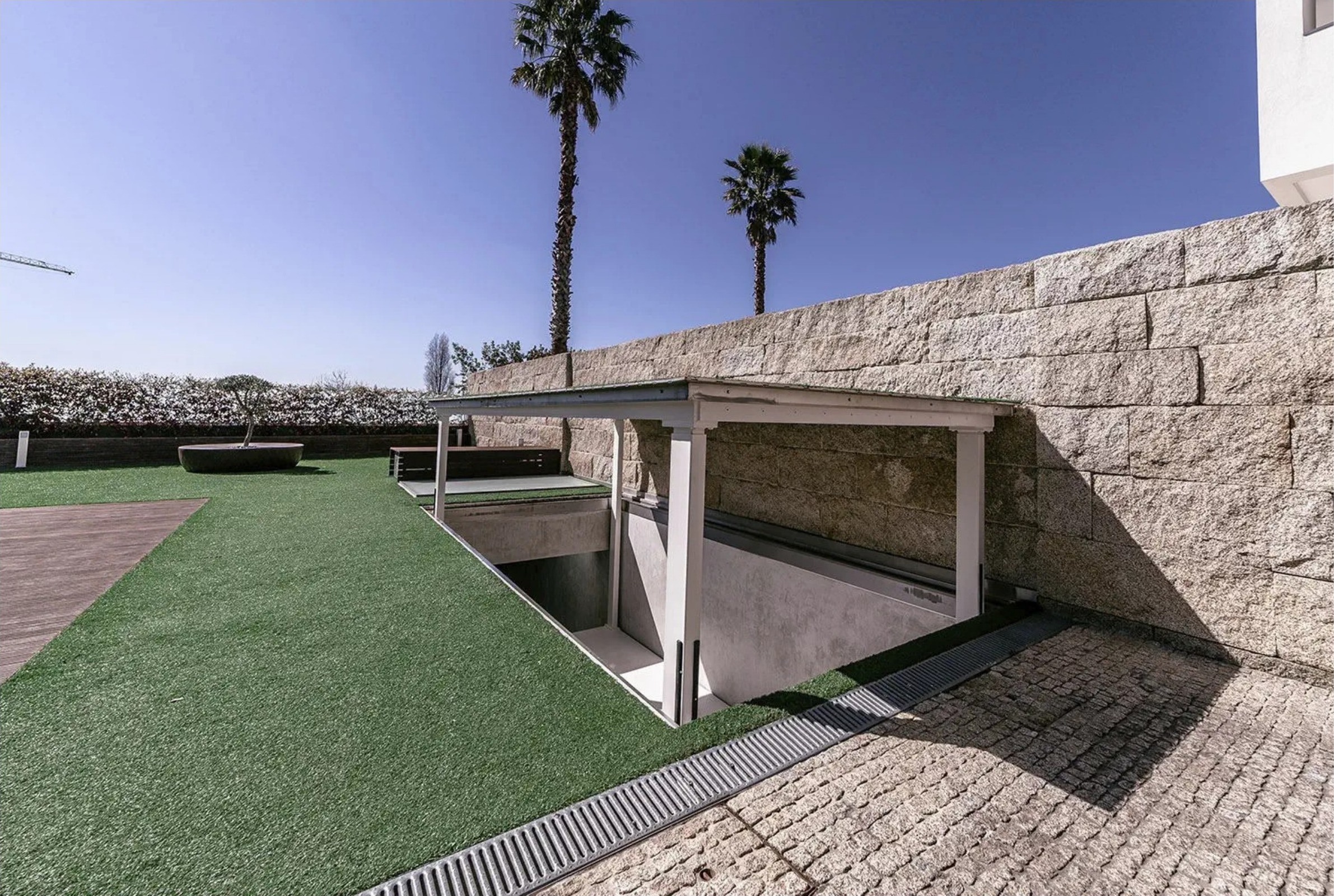 Liftech underground car-lift installation within a landscaped garden